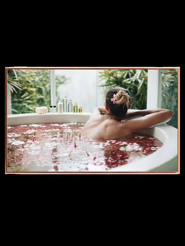 Kvinde badekar blomsterblade med vindue flasker